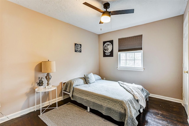 bedroom featuring ceiling fan, dark hardwood / wood-style flooring, and a textured ceiling