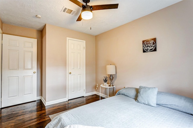 bedroom featuring a textured ceiling, ceiling fan, and dark wood-type flooring