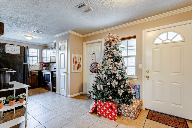 tiled foyer entrance featuring a wealth of natural light, crown molding, and a textured ceiling