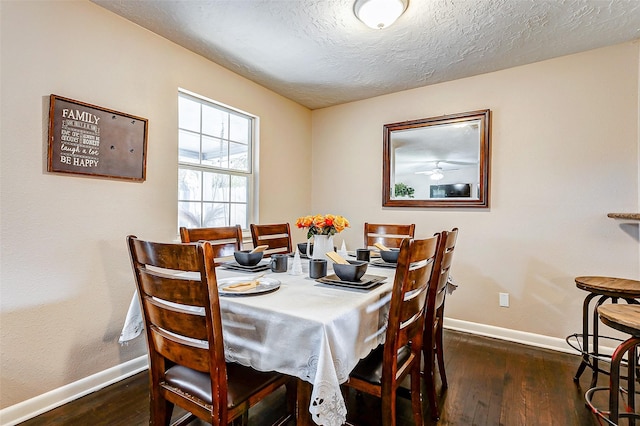 dining room featuring a textured ceiling and dark hardwood / wood-style floors