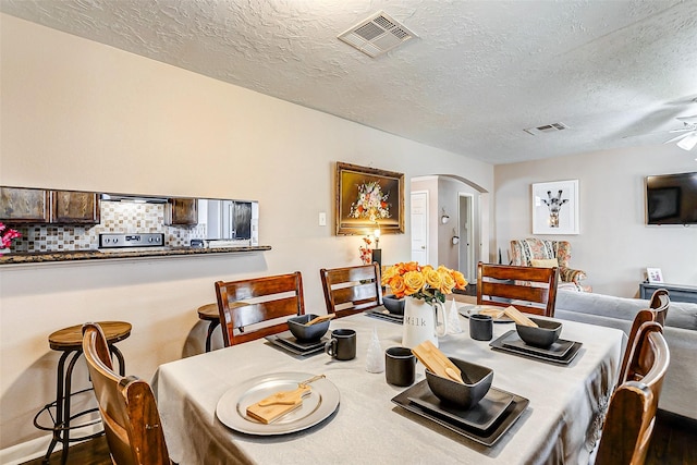 dining room featuring a textured ceiling, hardwood / wood-style flooring, and ceiling fan