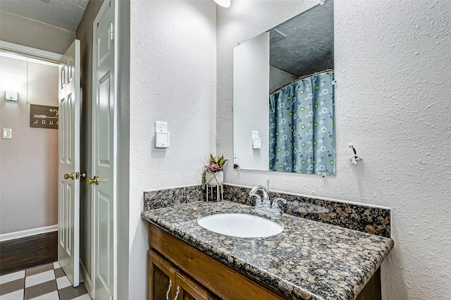 bathroom featuring a textured ceiling, vanity, and a shower with curtain