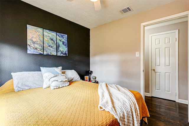 bedroom featuring a textured ceiling, ceiling fan, and dark wood-type flooring