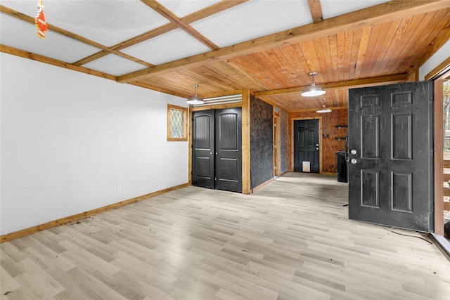 interior space with beam ceiling, wooden walls, and light hardwood / wood-style flooring