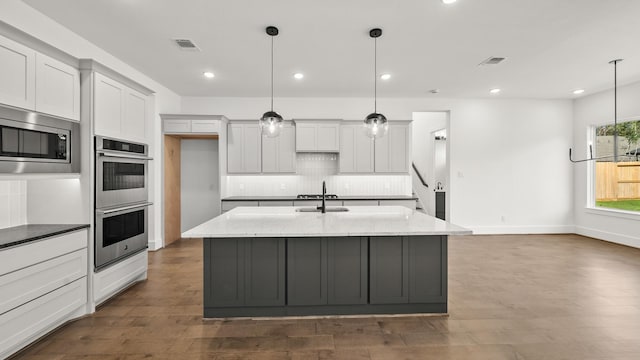 kitchen featuring light stone countertops, pendant lighting, and appliances with stainless steel finishes