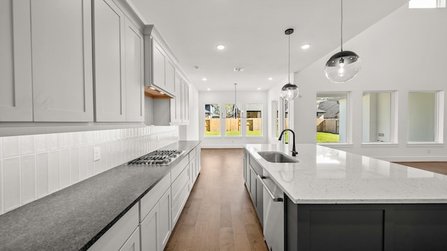 kitchen featuring white cabinets, dark hardwood / wood-style floors, a spacious island, and sink