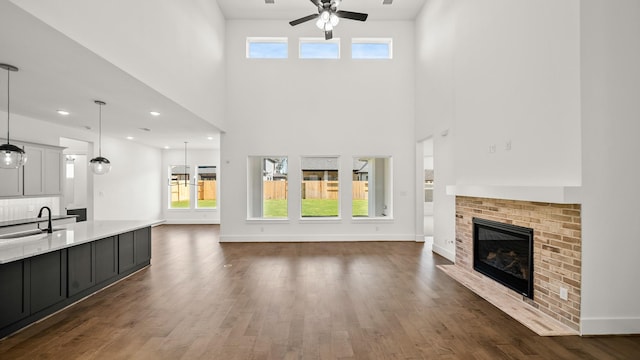 unfurnished living room featuring plenty of natural light, dark hardwood / wood-style floors, and sink