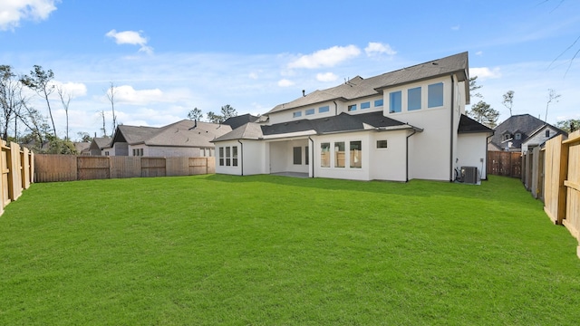 back of house featuring a yard and central air condition unit