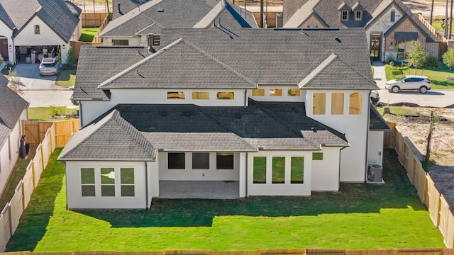 rear view of property with cooling unit, a yard, and a patio