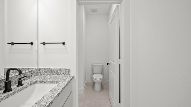 bathroom featuring tile patterned flooring, vanity, and toilet