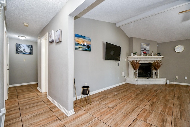 unfurnished living room with a fireplace, lofted ceiling with beams, and a textured ceiling