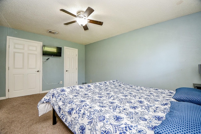 carpeted bedroom featuring ceiling fan and a textured ceiling