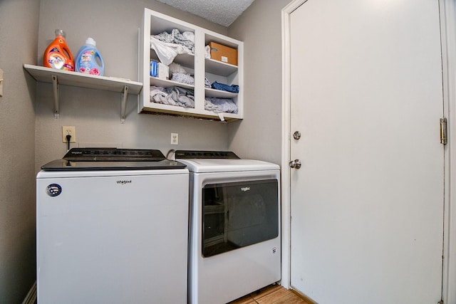 washroom featuring a textured ceiling and washing machine and dryer