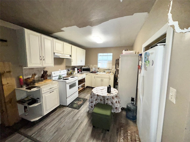 kitchen with white cabinetry, white appliances, and hardwood / wood-style flooring