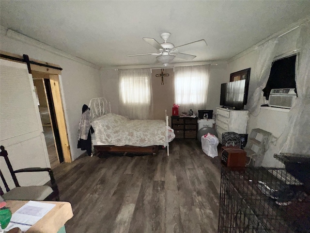 bedroom featuring ceiling fan, a barn door, wood-type flooring, and ornamental molding