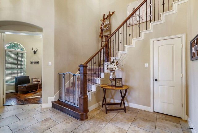 entrance foyer with light hardwood / wood-style flooring and a towering ceiling