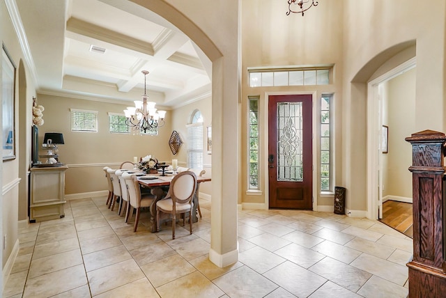 tiled foyer with beam ceiling, an inviting chandelier, crown molding, and coffered ceiling