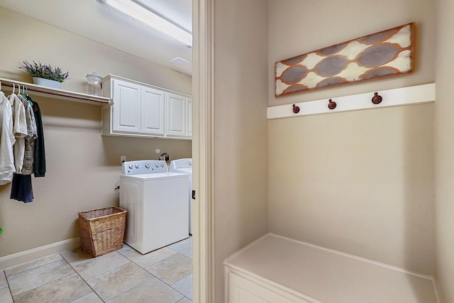 washroom with washer and dryer, light tile patterned flooring, and cabinets