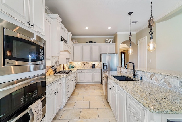 kitchen featuring sink, hanging light fixtures, light stone counters, crown molding, and white cabinets