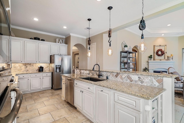 kitchen featuring a center island, white cabinets, sink, decorative light fixtures, and stainless steel appliances