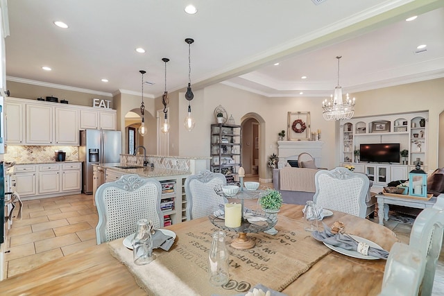 tiled dining area with ornamental molding, sink, and a chandelier