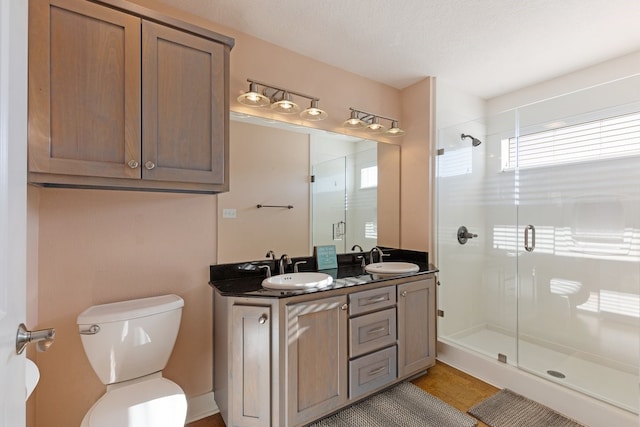 bathroom featuring tile patterned flooring, vanity, toilet, and an enclosed shower