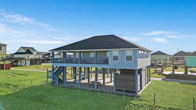 rear view of house with a lawn, a balcony, and a patio