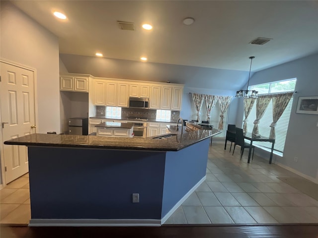 kitchen featuring white cabinets, a large island, sink, and appliances with stainless steel finishes