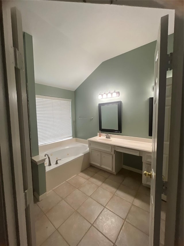 bathroom featuring vanity, tile patterned floors, a bathtub, and lofted ceiling