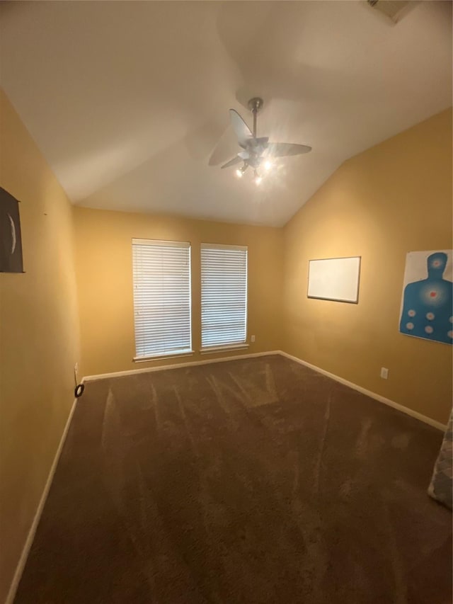 spare room with dark carpet, ceiling fan, and lofted ceiling