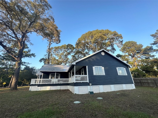 view of home's exterior featuring a porch and a lawn