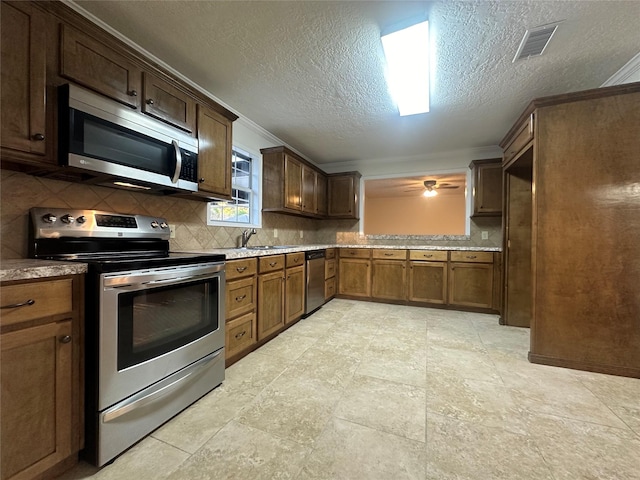 kitchen featuring decorative backsplash, sink, ornamental molding, and appliances with stainless steel finishes