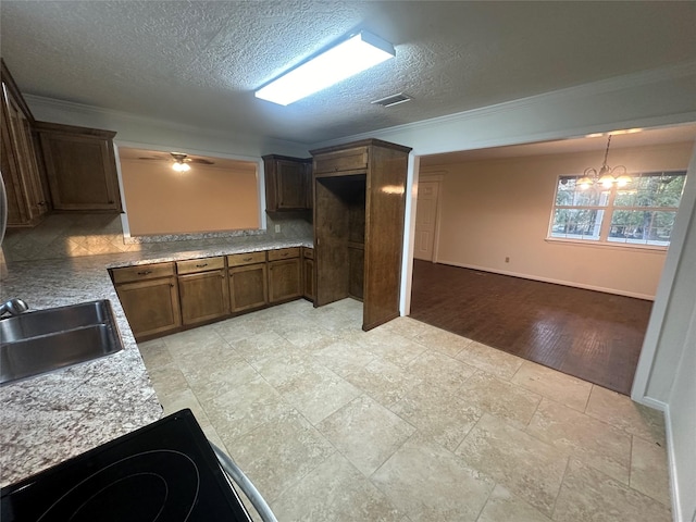 kitchen featuring sink, an inviting chandelier, backsplash, light wood-type flooring, and ornamental molding