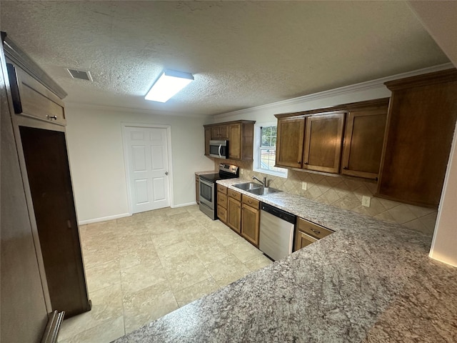 kitchen with appliances with stainless steel finishes, tasteful backsplash, ornamental molding, a textured ceiling, and sink