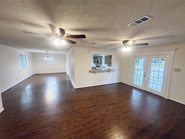 unfurnished living room with french doors, dark hardwood / wood-style floors, a textured ceiling, and ornamental molding