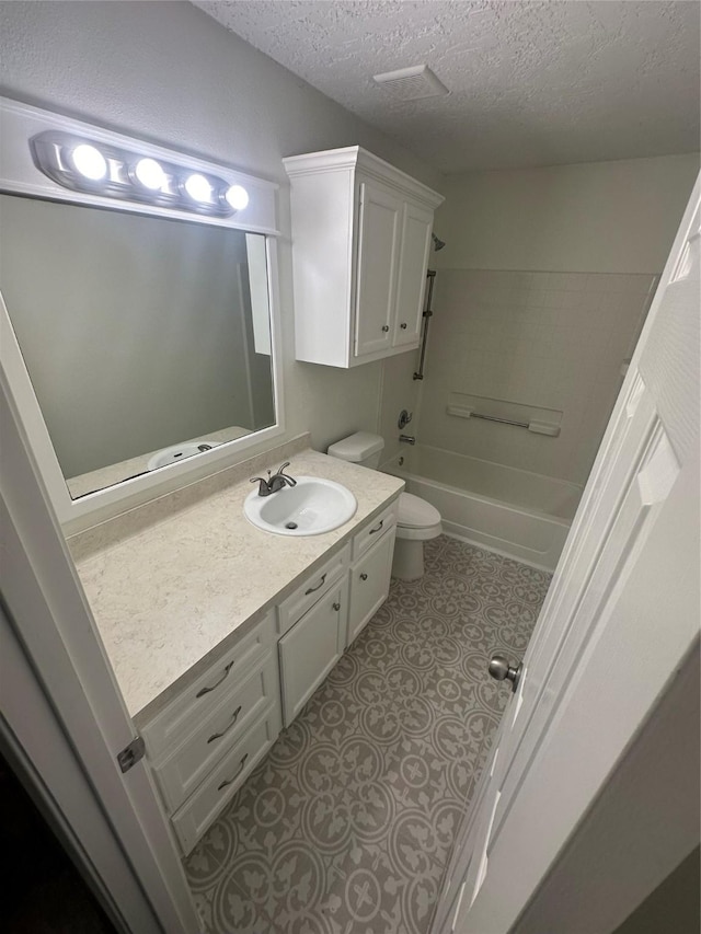 full bathroom with shower / bathing tub combination, vanity, toilet, and a textured ceiling