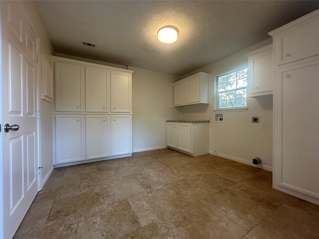 laundry room with washer hookup, electric dryer hookup, cabinets, and a textured ceiling