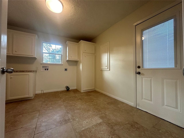 laundry area with hookup for a washing machine, cabinets, a textured ceiling, and hookup for an electric dryer