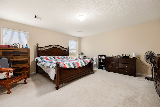 bedroom with light carpet and a textured ceiling