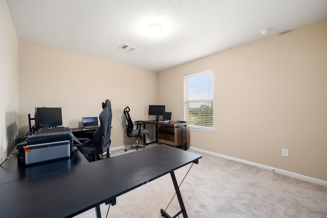 carpeted office space featuring a textured ceiling