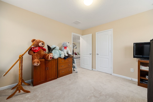 bedroom featuring a textured ceiling and light carpet