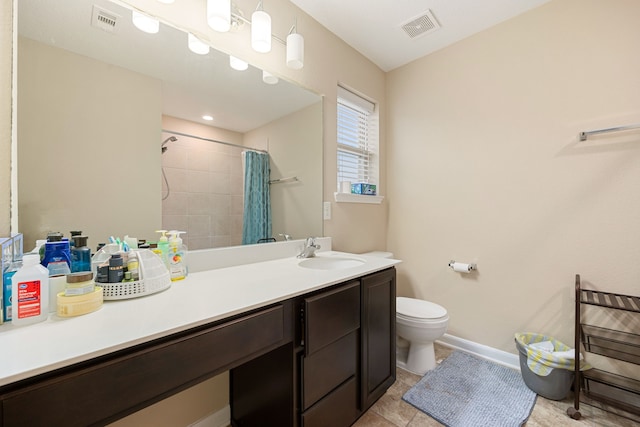 bathroom with tile patterned floors, vanity, toilet, and walk in shower