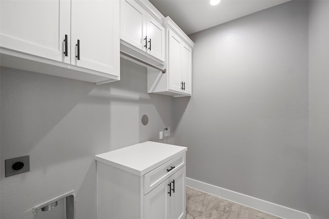 laundry room with electric dryer hookup and cabinets