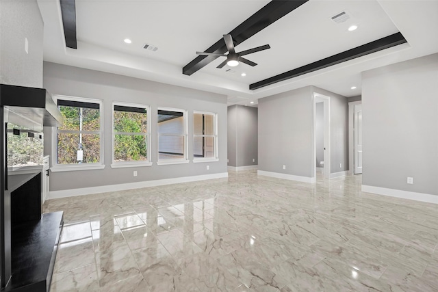 unfurnished living room featuring ceiling fan and a raised ceiling