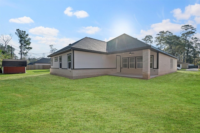 rear view of house with a lawn, ceiling fan, and a patio area