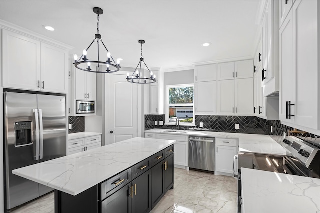 kitchen featuring white cabinetry, a center island, hanging light fixtures, light stone counters, and appliances with stainless steel finishes