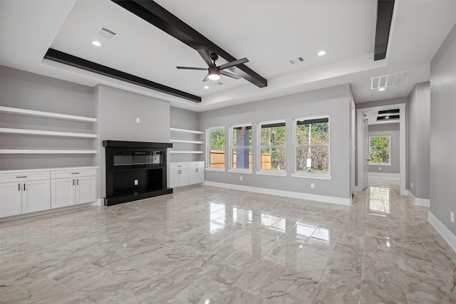 unfurnished living room with beamed ceiling, ceiling fan, a raised ceiling, and built in shelves