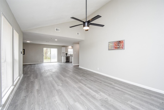 unfurnished living room featuring high vaulted ceiling, light hardwood / wood-style floors, and ceiling fan