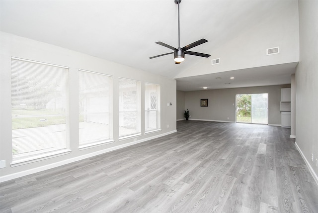 unfurnished living room with ceiling fan, high vaulted ceiling, and light wood-type flooring