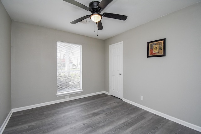 spare room featuring dark wood-type flooring and ceiling fan